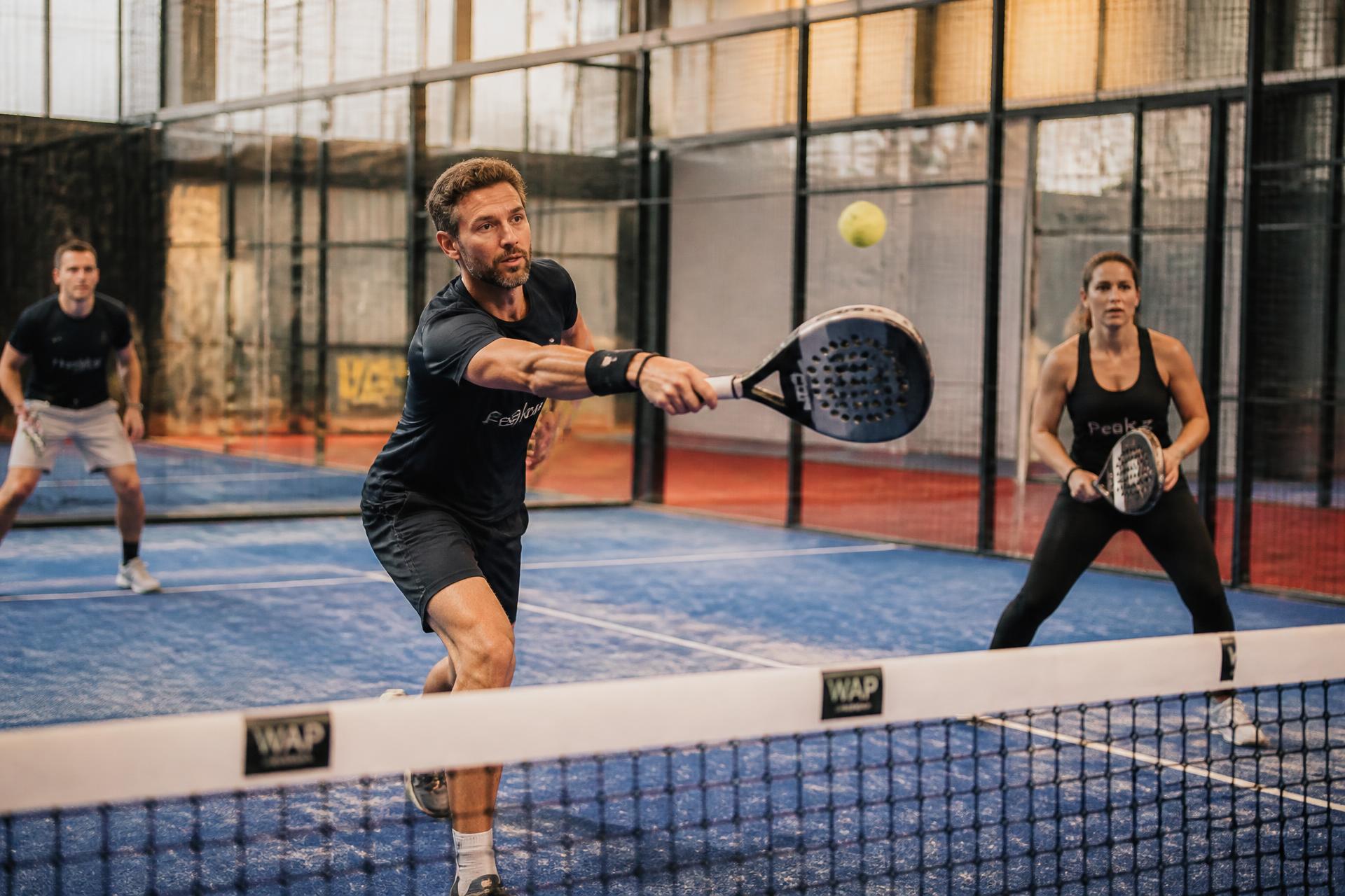 Spelers in een rally op een indoor padelterrein
